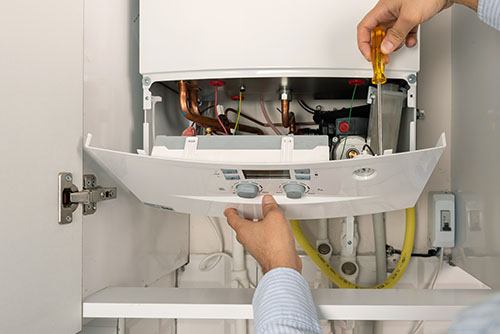 Heating technician repairing a residential boiler in Ladera Ranch