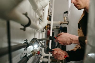 Technician inspecting commercial plumbing pipes in Ladera Ranch