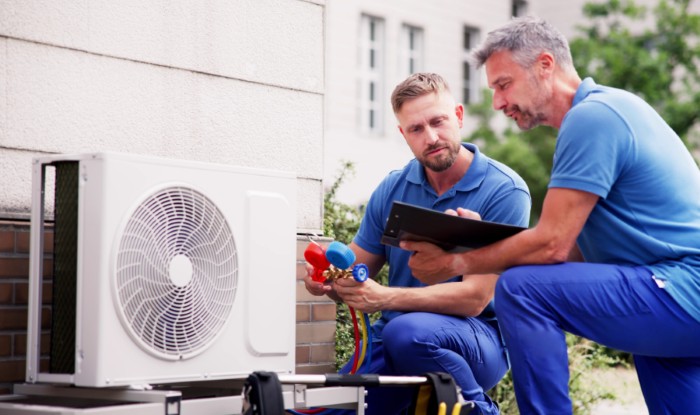 HVAC technicians installing an outdoor air conditioning unit in Ladera Ranch