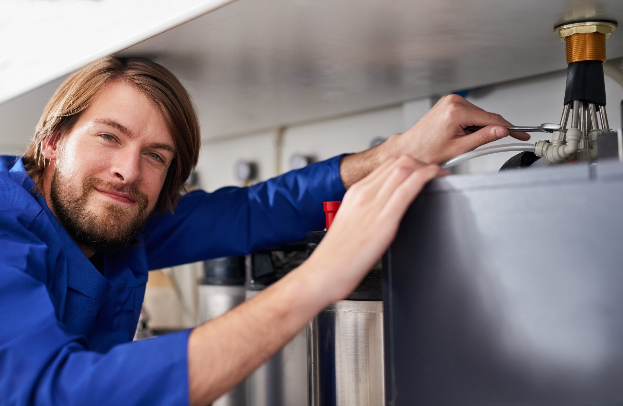 Technician servicing a residential water heater tank in Ladera Ranch